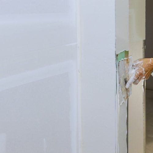 worker-spreading-coating-plaster-the-walls-with-pu-7RRVQXF